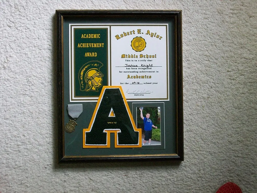 Academic achievement award framed with a varsity letter A, a pin and a photo